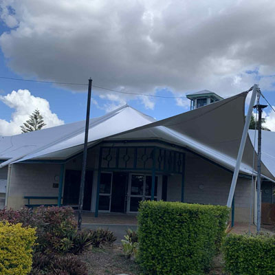 Waterproof shade sail showing steep pitch for correct rainwater runoff